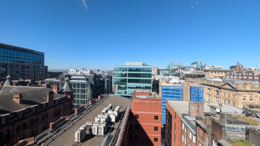 La vista desde una de las ventanas del edificio donde se realizó la conferencia. Se ve un cielo azul y los techos de algunos edificios de la ciudad de Glasgow.